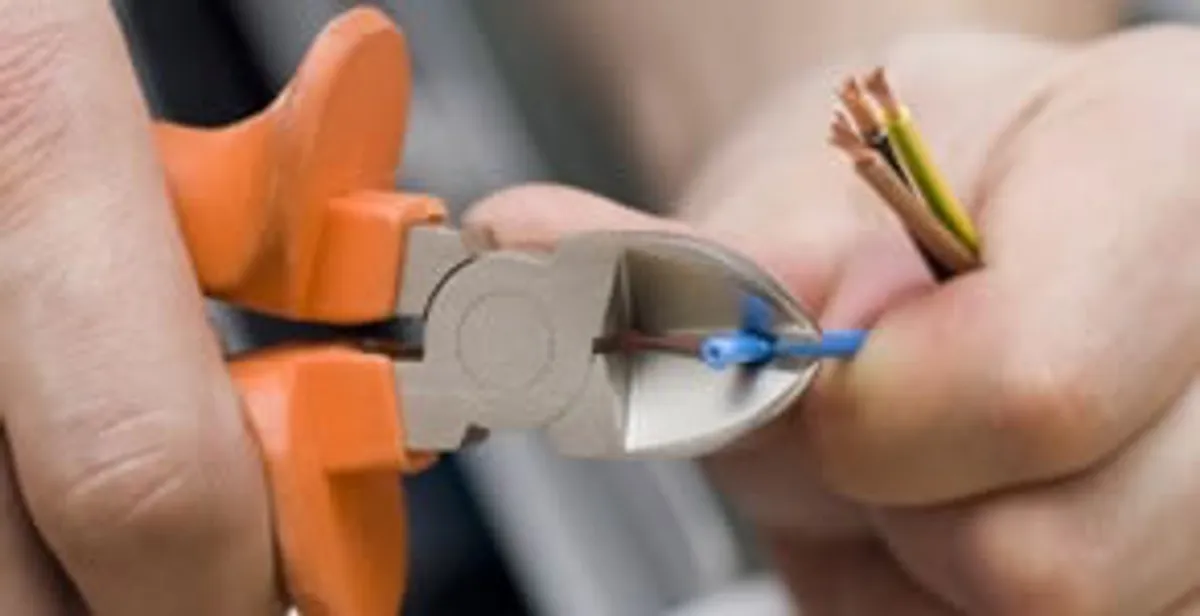 licensed electrician performing precise wire cutting and preparation during electrical service in Charleston, SC