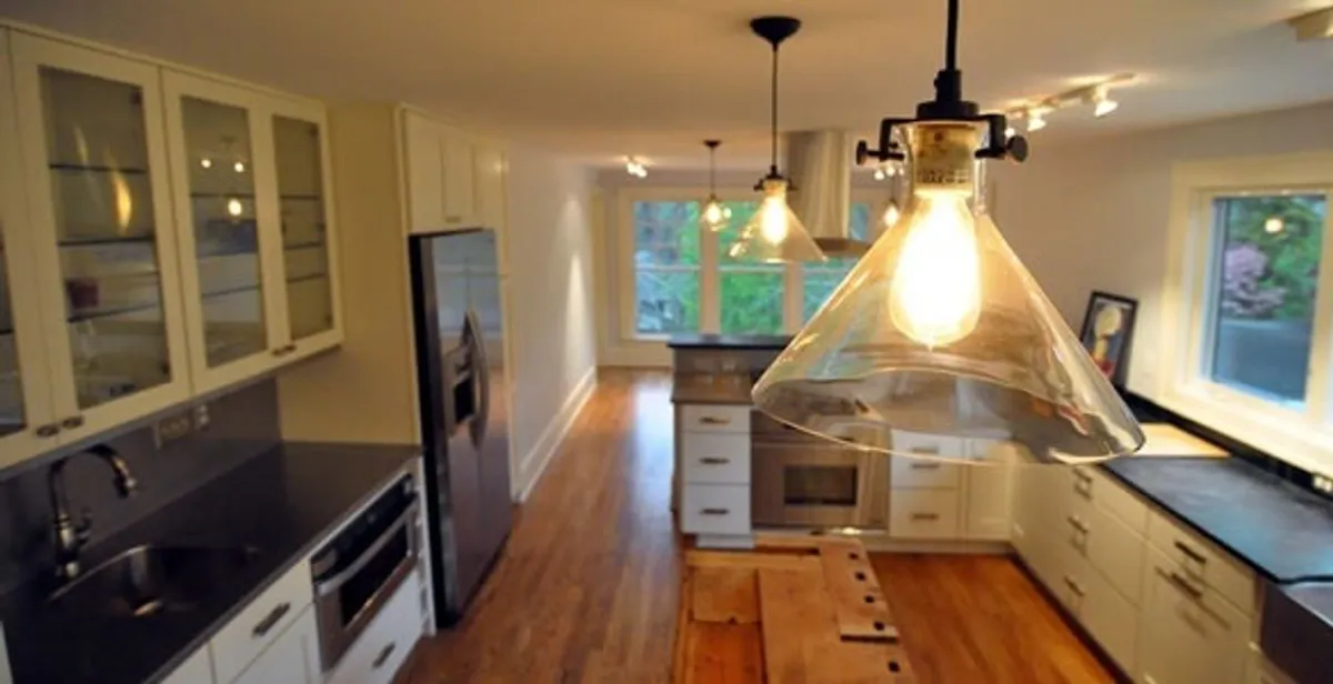 Residential electrician installing modern indoor light fixture in a home in Charleston, SC